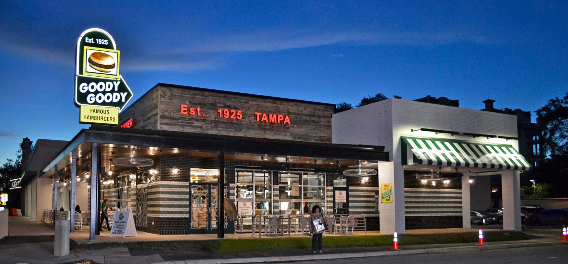 Goody Goody restaurant in Tampa featuring illuminated pylon sign, wall signage, and striped awning at night