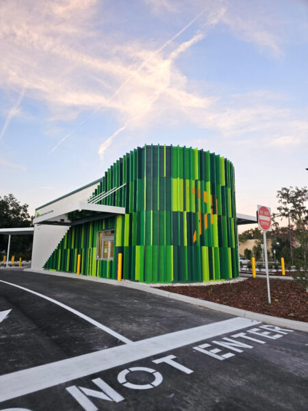 Green Lane facility exterior with custom architectural branding and green panel facade design