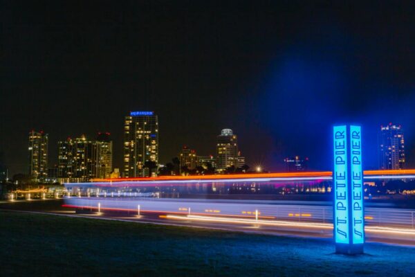 Illuminated wayfinding sign at St Pete Pier guiding visitors at night along waterfront