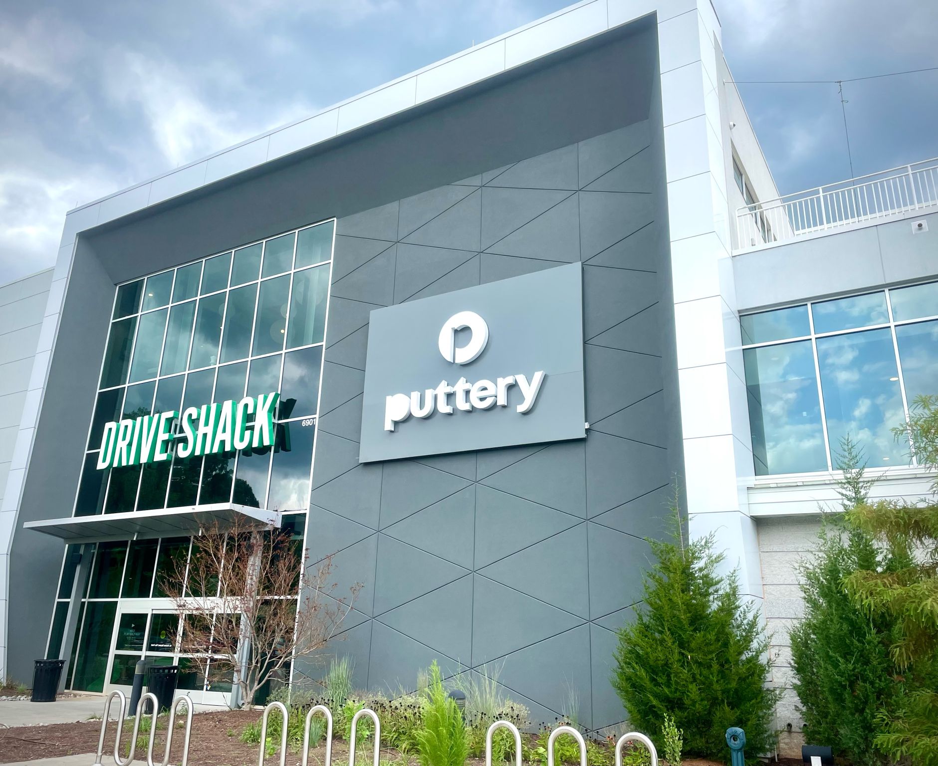 Wall-mounted commercial sign for Puttery and Drive Shack on modern building exterior