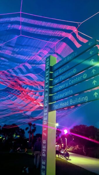 Directional wayfinding signage system with arrows guiding visitors to multiple destinations in outdoor public space