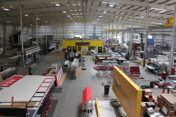 Commercial sign manufacturing facility with large-scale fabrication equipment and production workspace