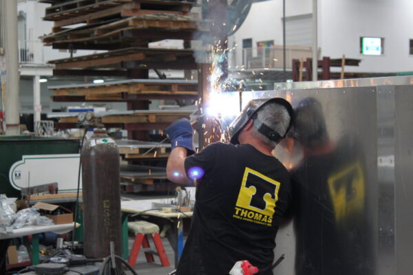 Sign fabrication welding process in manufacturing facility for structural signage components