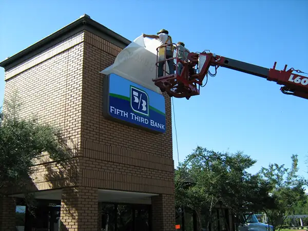Technicians installing new Fifth Third Bank signage during a rebranding conversion project by Thomas Sign & Awning