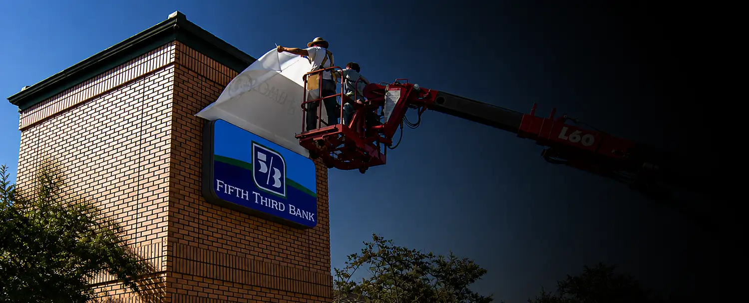 Technicians replacing a bank sign during a rebranding and conversion project by Thomas Sign & Awning