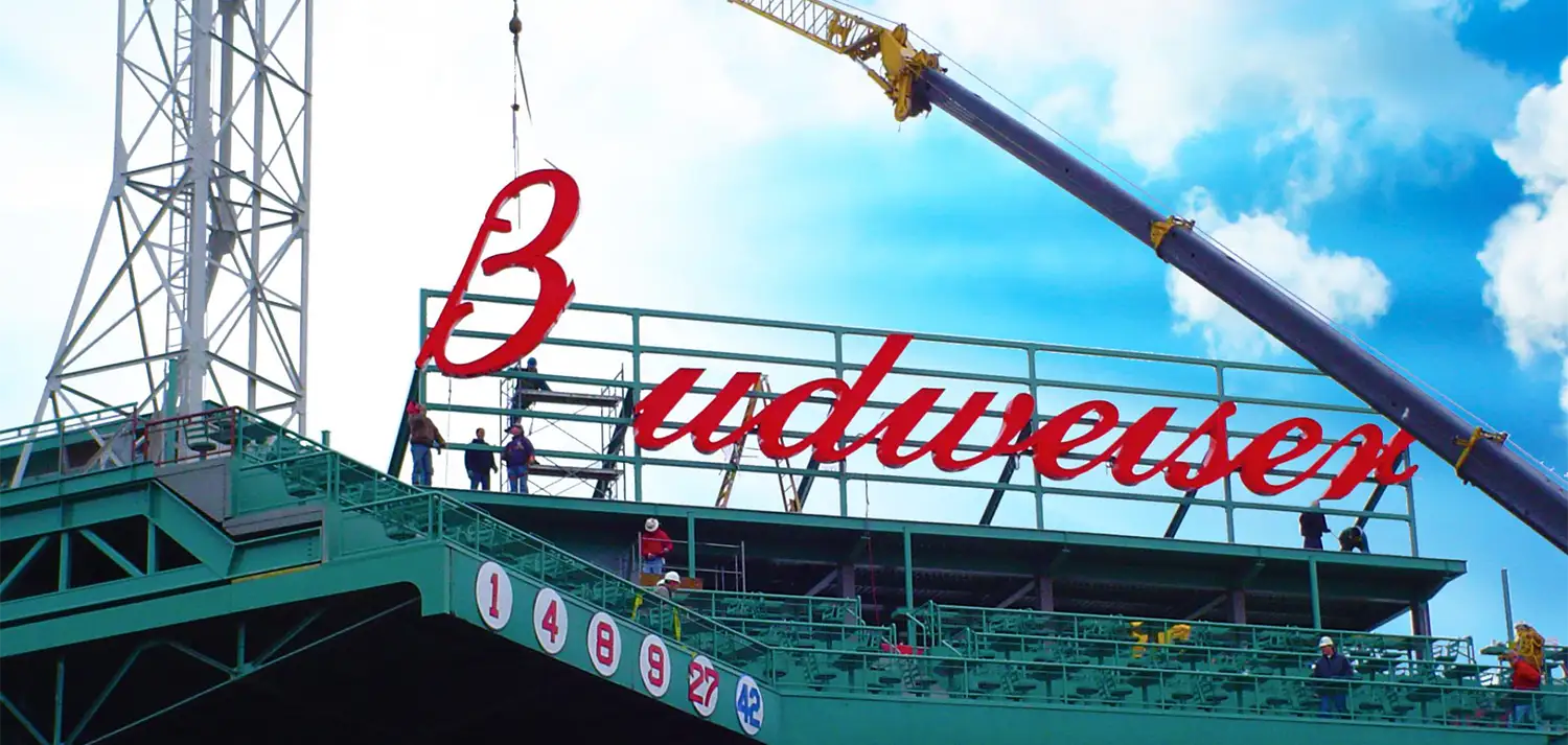 Commercial signage installation crew working on large exterior building sign for quote request page