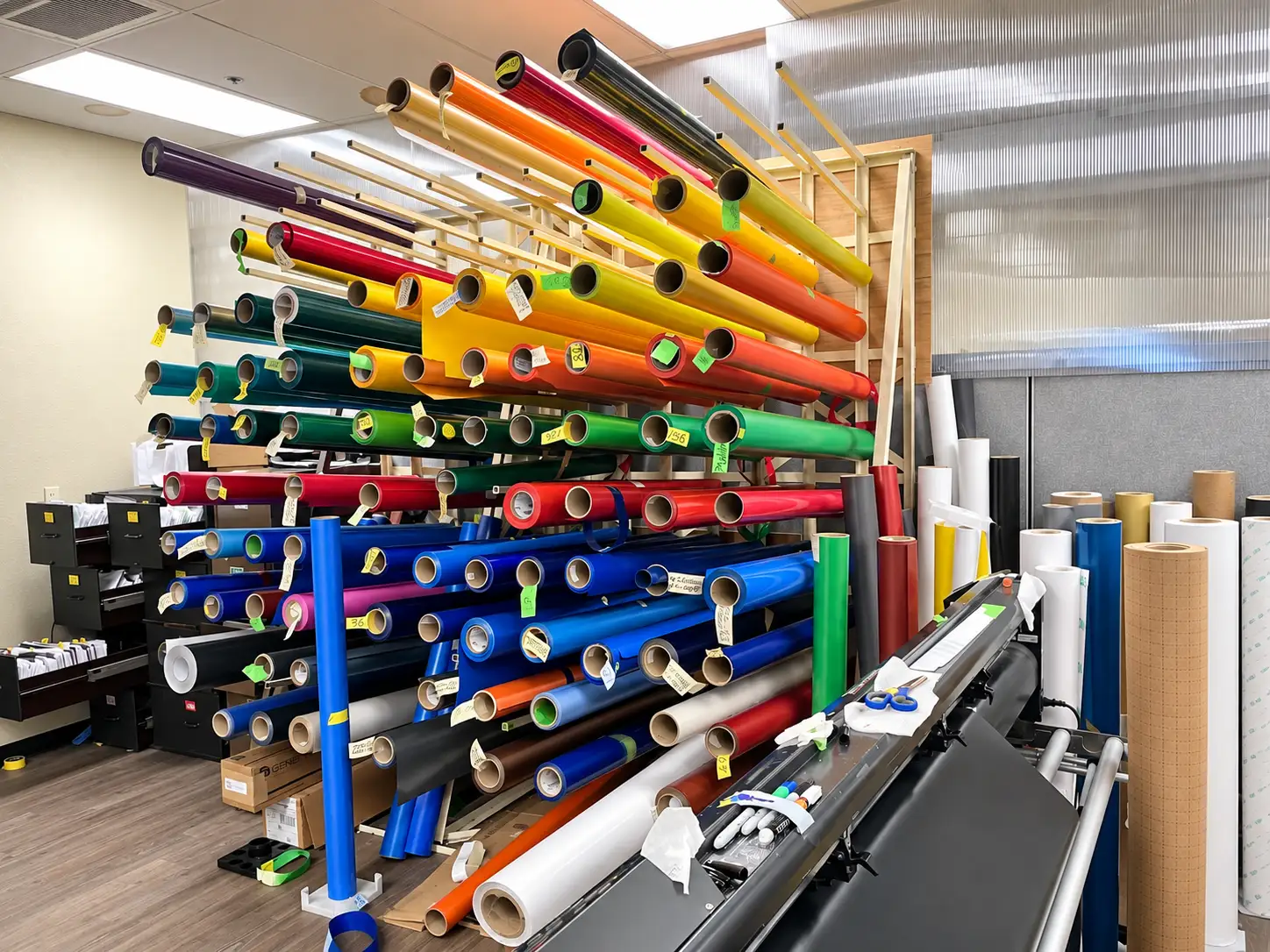 Colorful vinyl rolls organized for commercial sign graphics production at Thomas Sign & Awning.