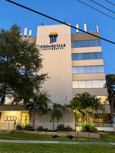 Illuminated Cedarville University channel letter sign and logo on a commercial building in Clearwater, Florida.