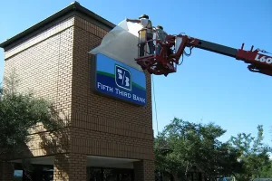 Technicians installing new Fifth Third Bank signage during a rebranding conversion project by Thomas Sign & Awning