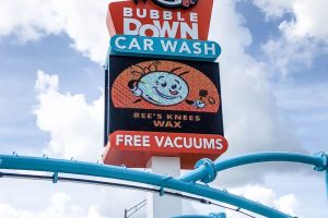 Pylon sign with electronic message center at Bubble Down Car Wash displaying digital advertising
