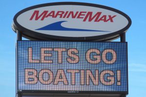 LED electronic message center display showing Lets Go Boating message on MarineMax sign